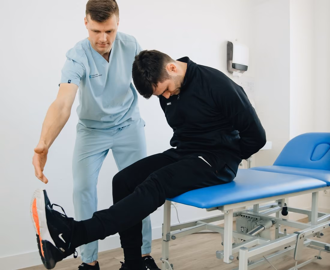 Fizik tedavi kliniğinde fizyoterapist, danışanına egzersiz yaptırıyor