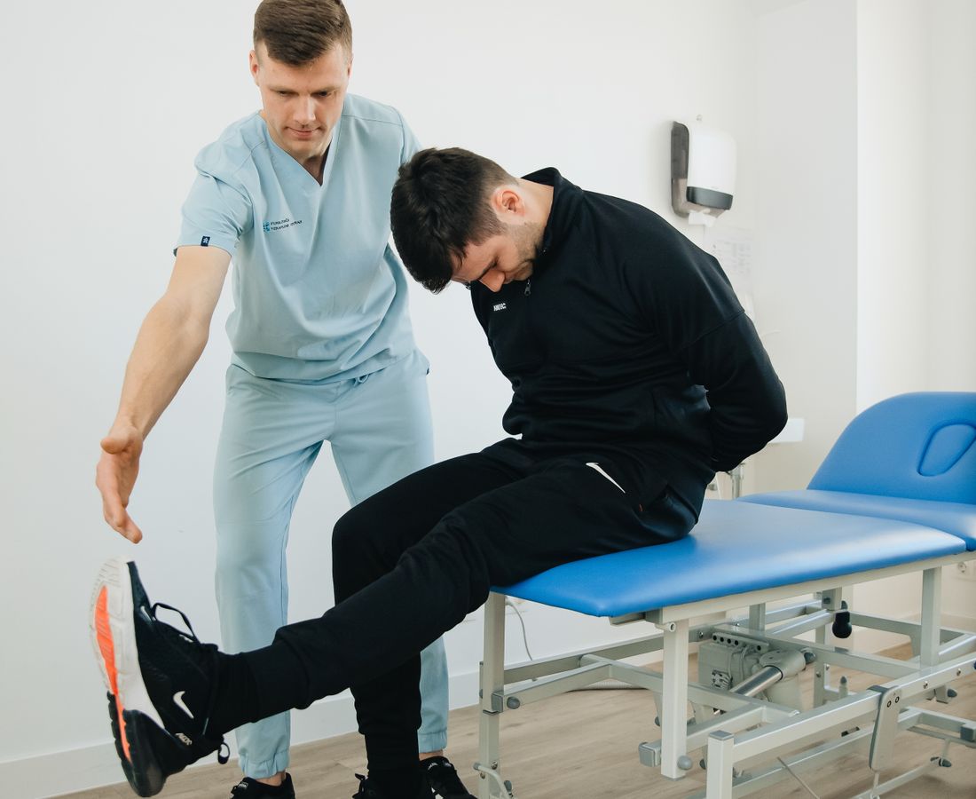 Fizik tedavi kliniğinde fizyoterapist, danışanına egzersiz yaptırıyor